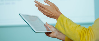 Eine Lehrerin hält ein Tablet Insegnante con tablet in mano